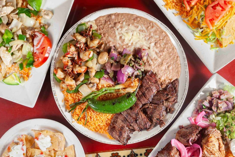 A beautiful plate of refried beans, spiced rice, braised beef, red onions and charred chili pepper