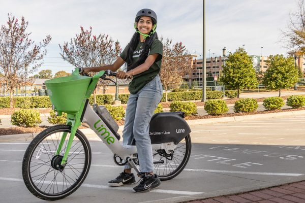Charlotte student poses on Lime e-bike
