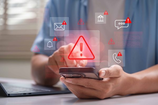 person texting on phone with red alert icons floating above.