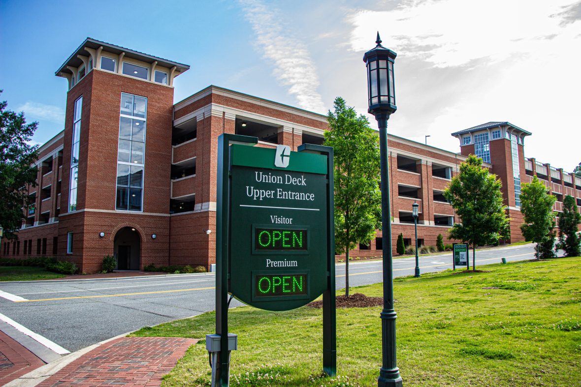 Union Upper Deck sign with green open text. Brick parking deck in background.