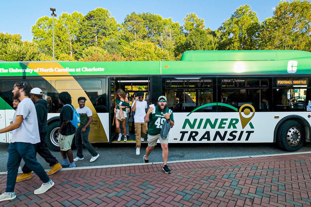 Football fans getting off Niner Transit bus.