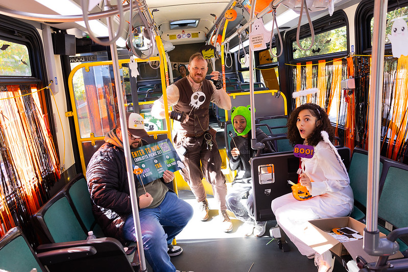 People dressed in costumes on a Niner Transit Bus decorated for Halloween.